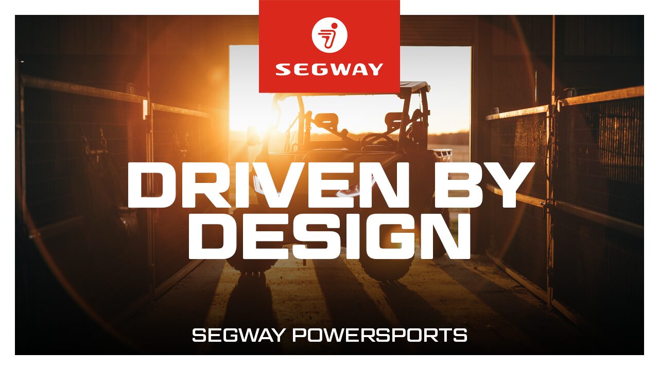 Segway Utility Vehicle with the sun shining in the background with text the reads "Driven by design - Segway Powersports"